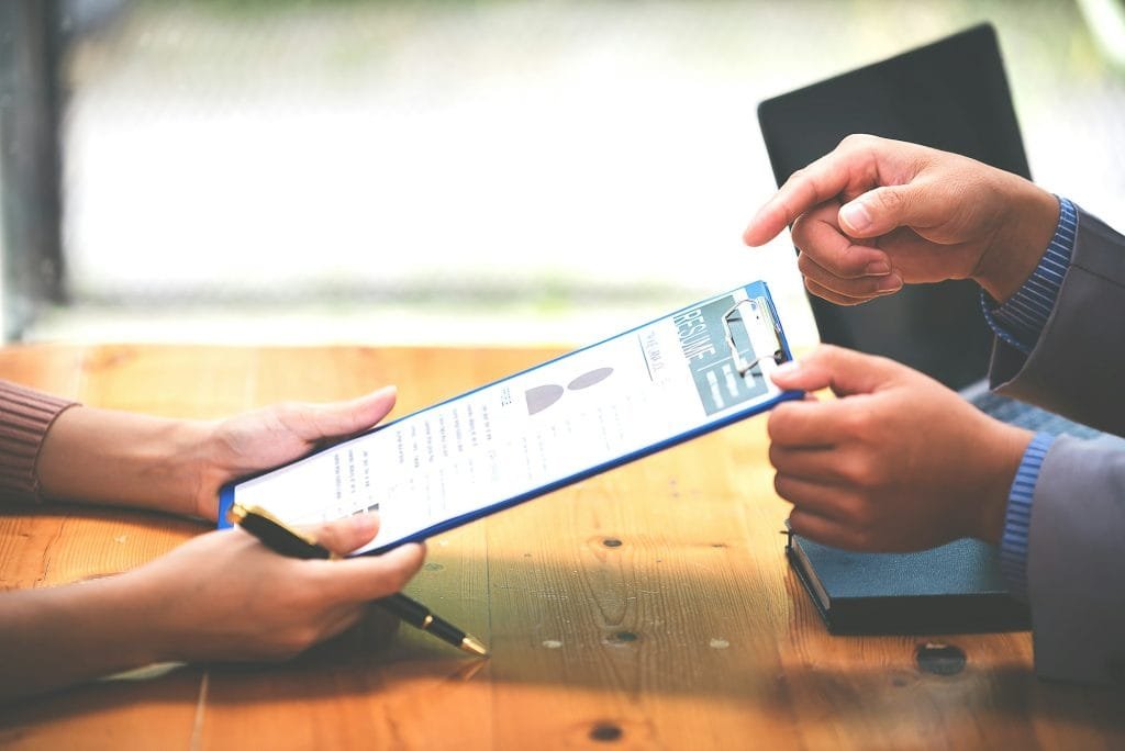 Woman submits her employer's resume to review job applications. Concept showcases her ability to get resources.