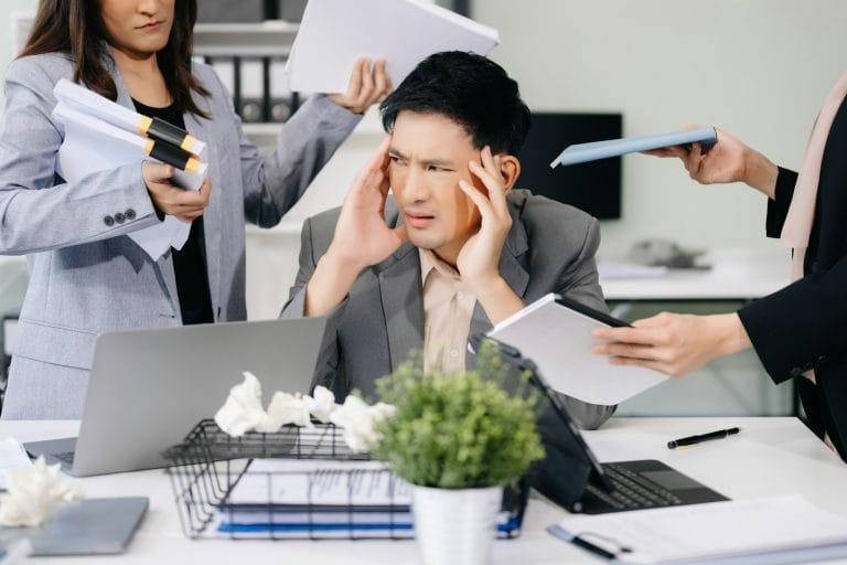 Stressed Asian Businesswoman Surrounded by Overwhelming Paperwork Concept of Workplace Anxiety